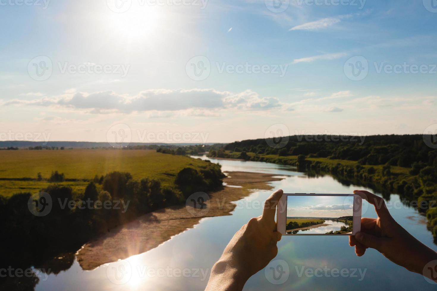 alguém usando o smartphone para tirar uma foto de uma paisagem de verão