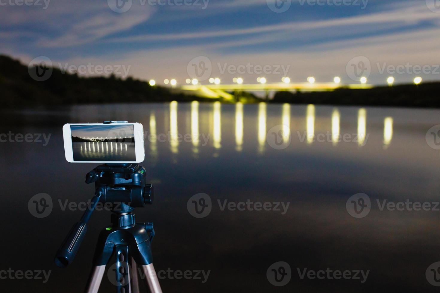 usando smartphone como uma câmera profissional no tripé para capturar paisagens noturnas foto