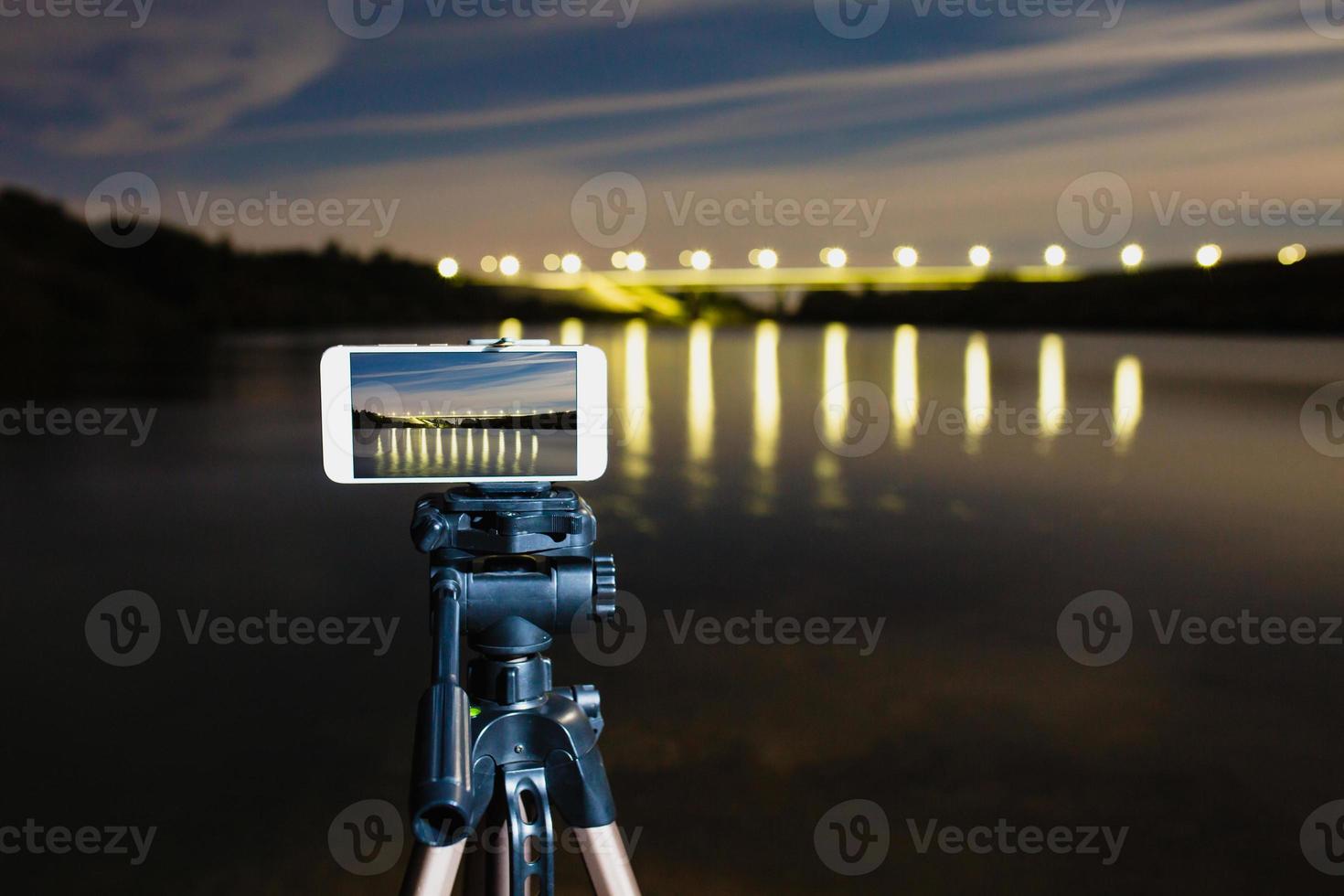 usando smartphone como uma câmera profissional no tripé para capturar paisagens noturnas foto