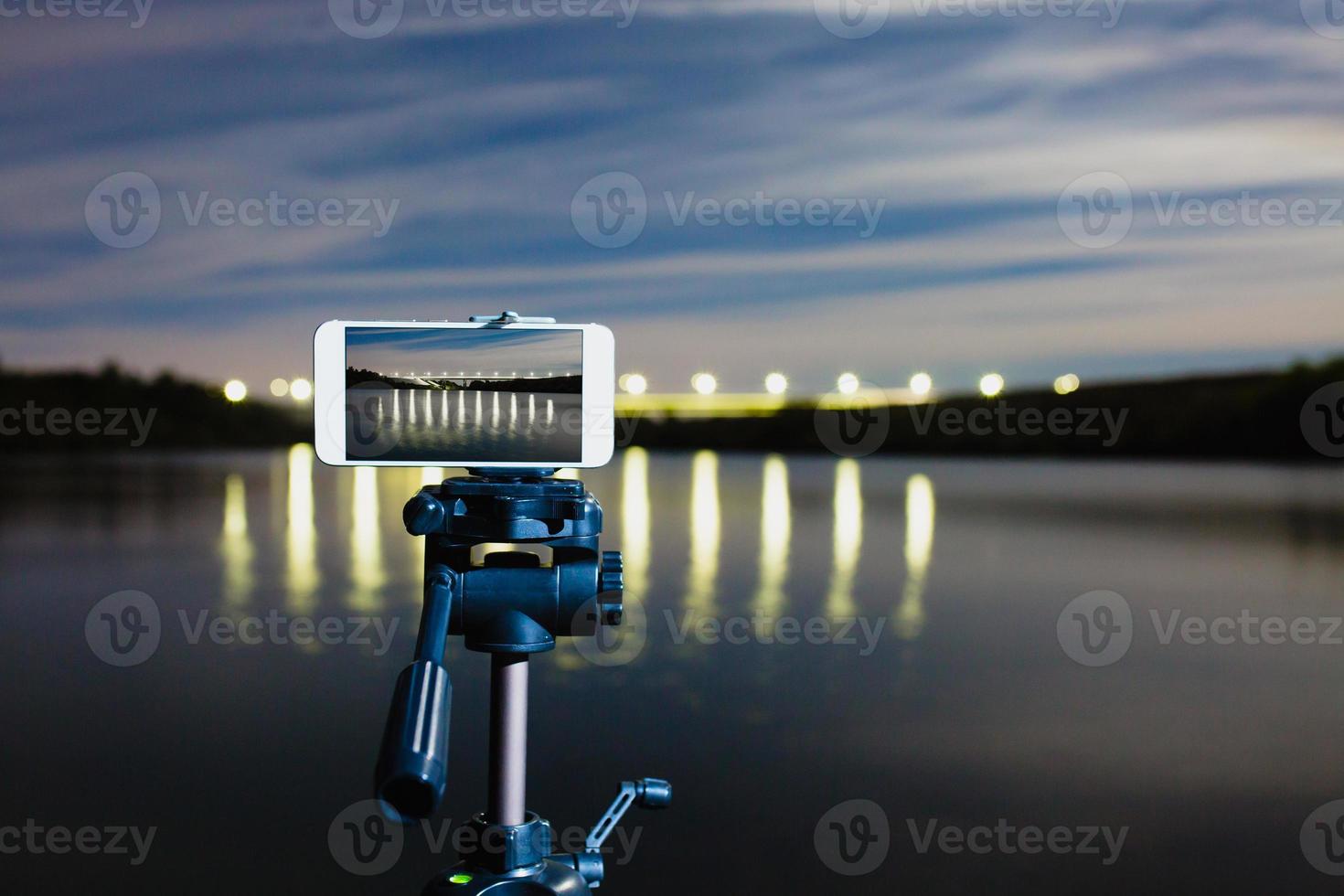 usando smartphone como uma câmera profissional no tripé para capturar paisagens noturnas foto