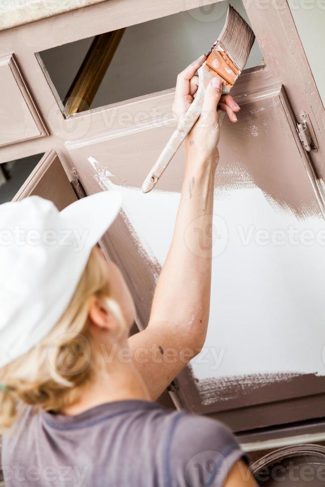 closeup de mulher pintando armários de cozinha foto