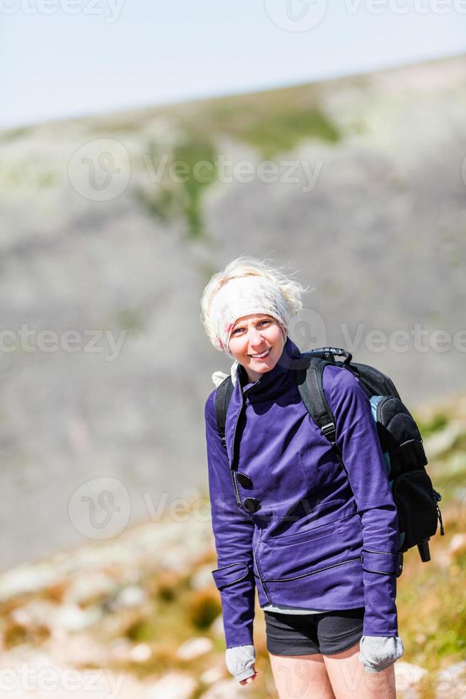 mulher caminhando em uma trilha rochosa foto