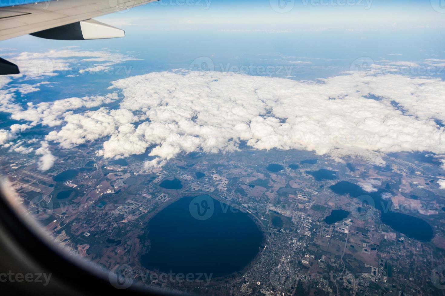 asa do jato e cloudscape branco no céu azul da janela foto