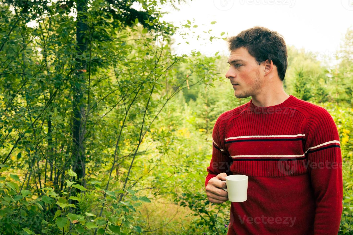 jovem na natureza com uma caneca de café foto