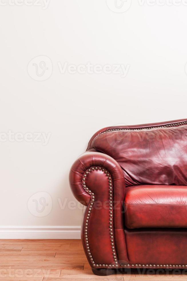 luxuoso sofá de couro vermelho em frente a uma parede vazia foto