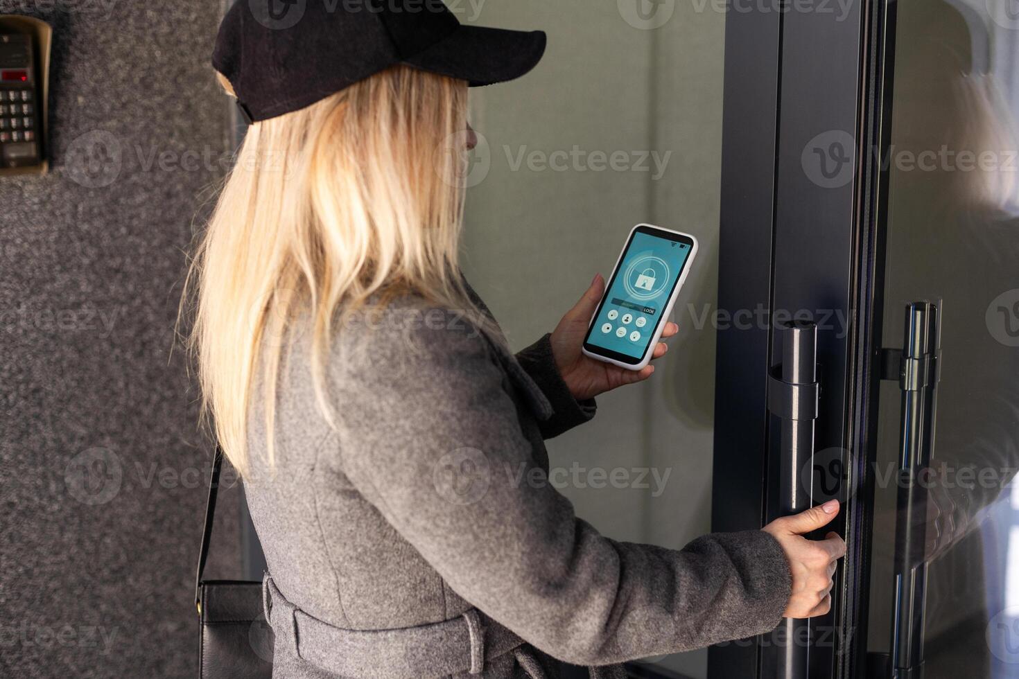 mulher travamento cadeado inteligente em a Entrada porta usando uma inteligente telefone. conceito do usando inteligente eletrônico fechaduras com sem chave acesso. foto