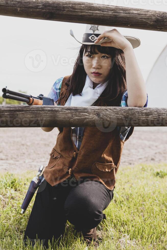retrato do uma lindo chinês fêmea vaqueira tiroteio com uma arma foto
