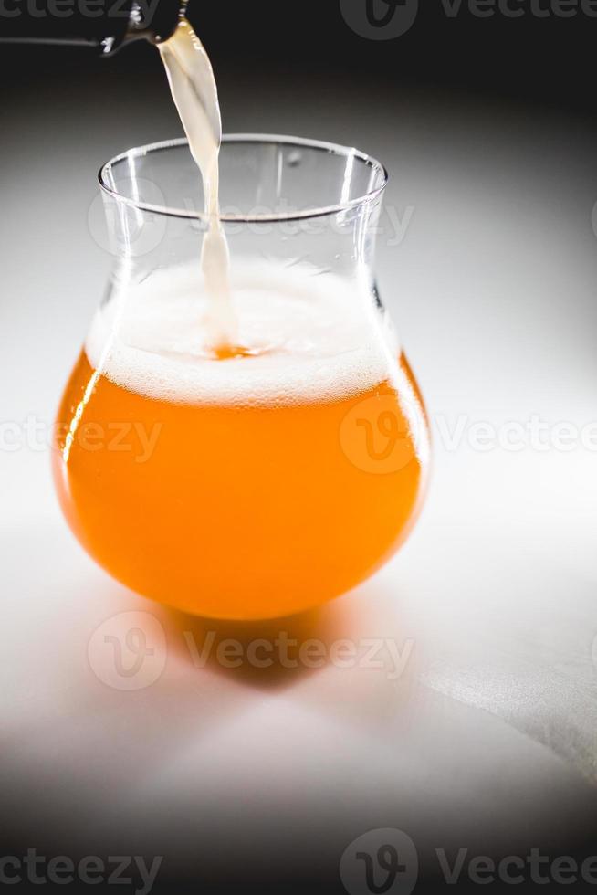 copo de close-up de cerveja de ruibarbo caseiro com espuma branca. foto