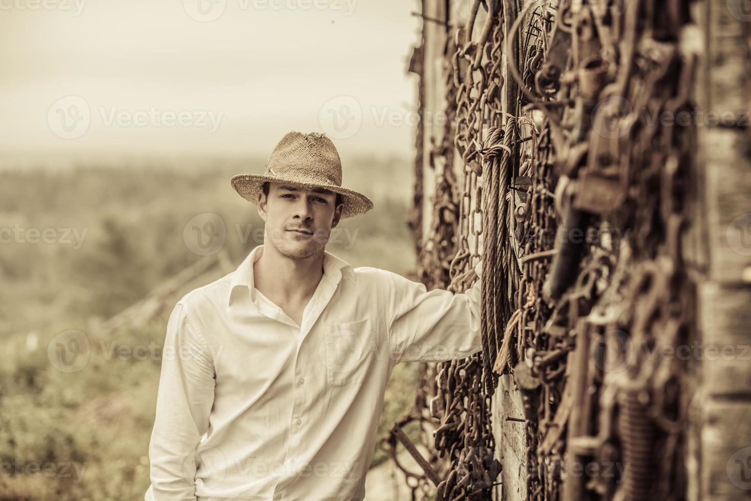 retrato de fazendeiro em frente a uma parede cheia de ferramentas foto