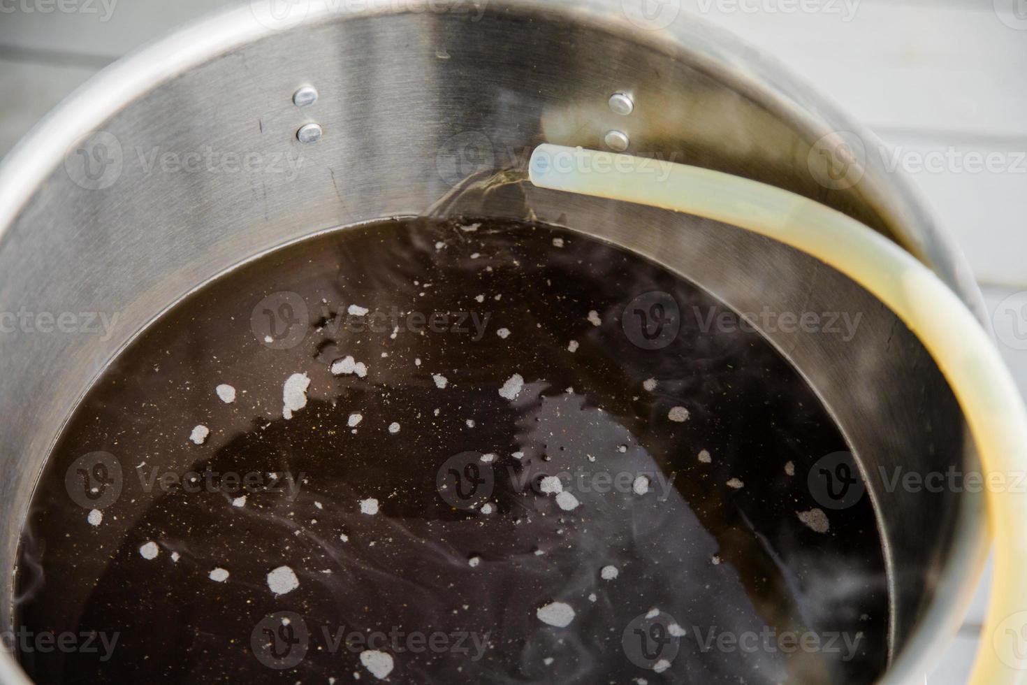 despejando mosto de cerveja artesanal caseira na chaleira de fervura foto