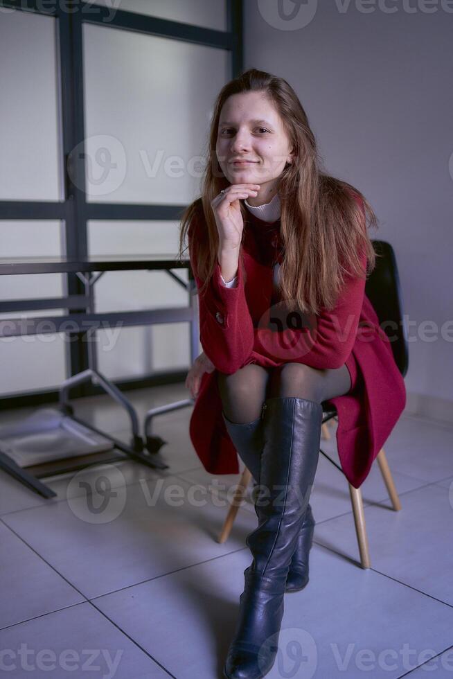 retrato do uma jovem mulher dentro uma vermelho escritório terno foto