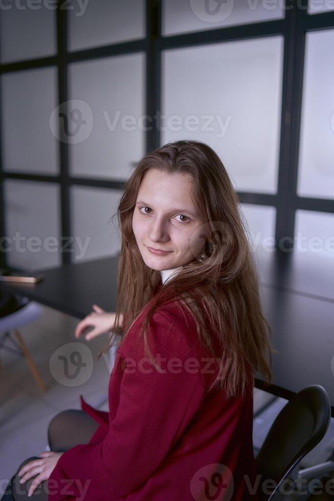 retrato do uma jovem mulher dentro uma vermelho escritório terno foto