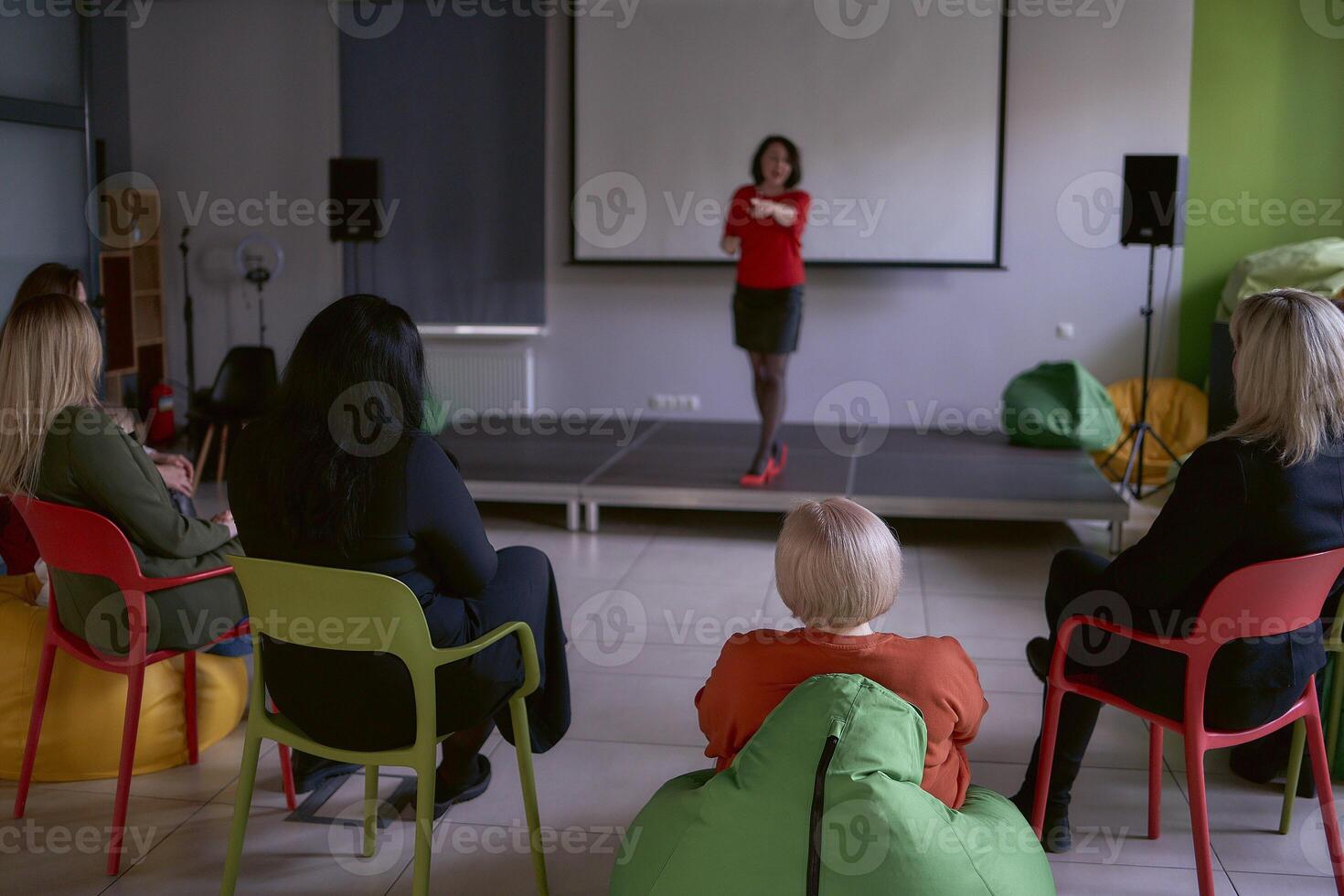 mulher dando emocional discurso em estágio, desempenho corredor dentro escritório foto