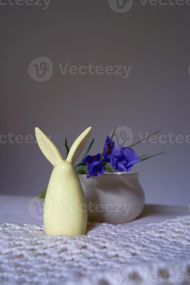 minimalista íris em branco cerâmico vaso em mesa com Páscoa Coelho foto