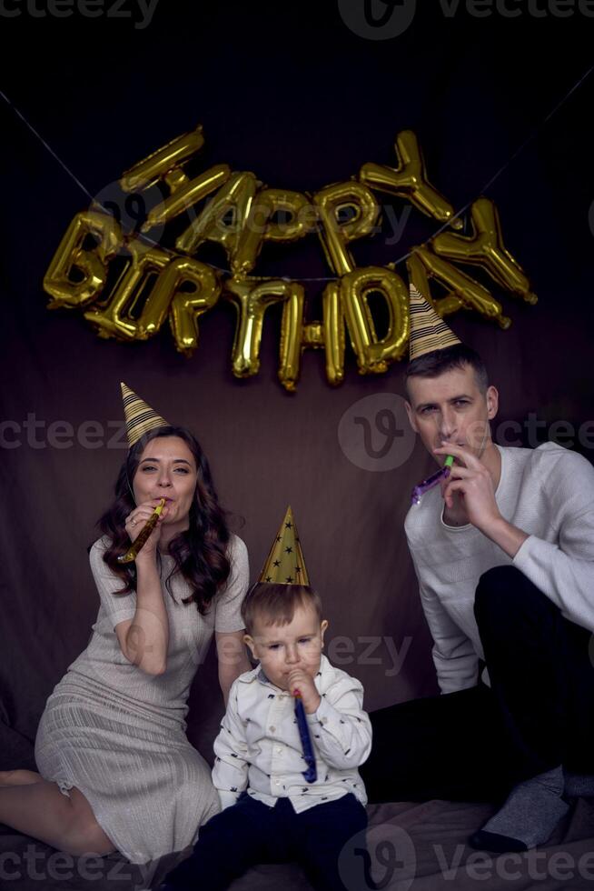 família a comemorar infantil aniversário vestindo festa chapéus sopro tubos foto