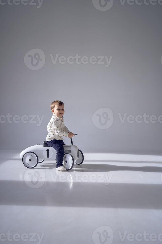 uma criança pequena é entusiasticamente jogando com dele brinquedo carro em dele aniversário foto