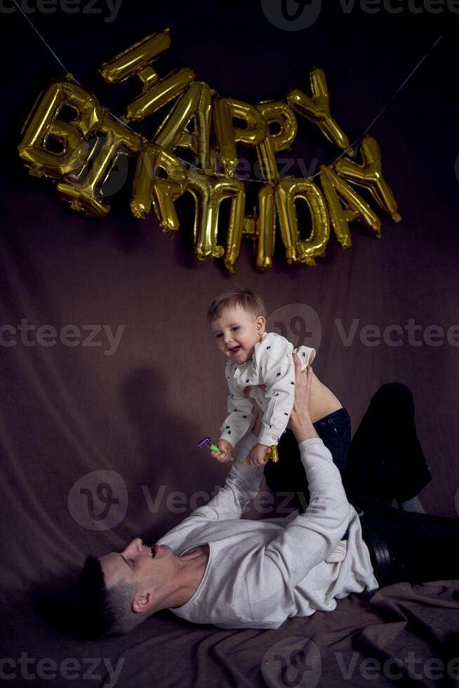 Papai é jogando com dele filho em dele aniversário foto