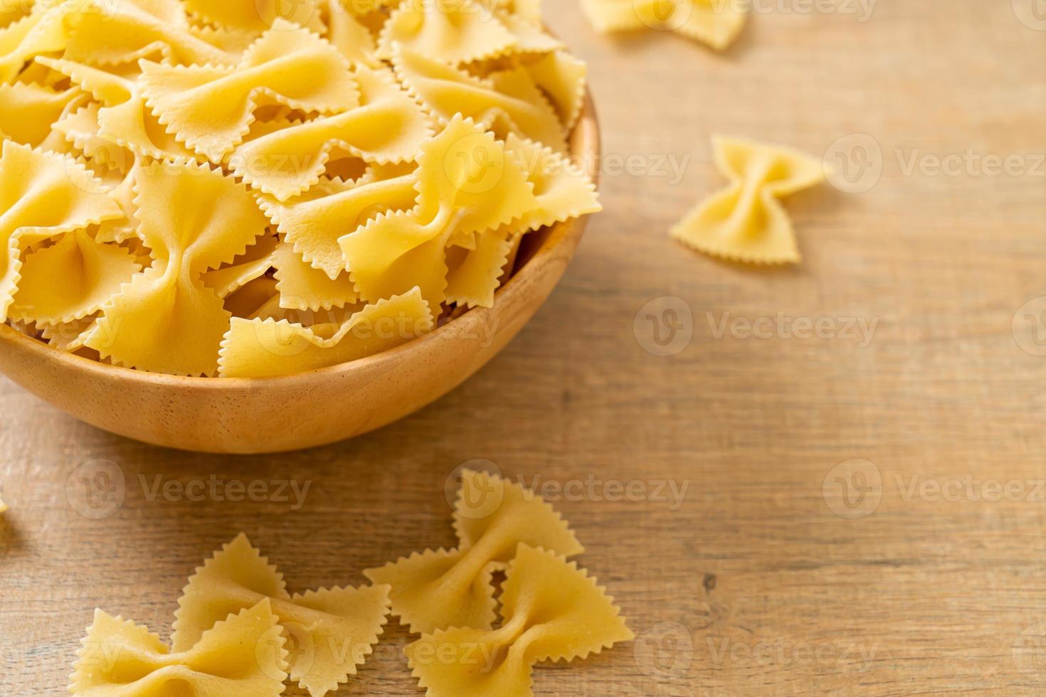 macarrão farfalle seco e cru na tigela foto