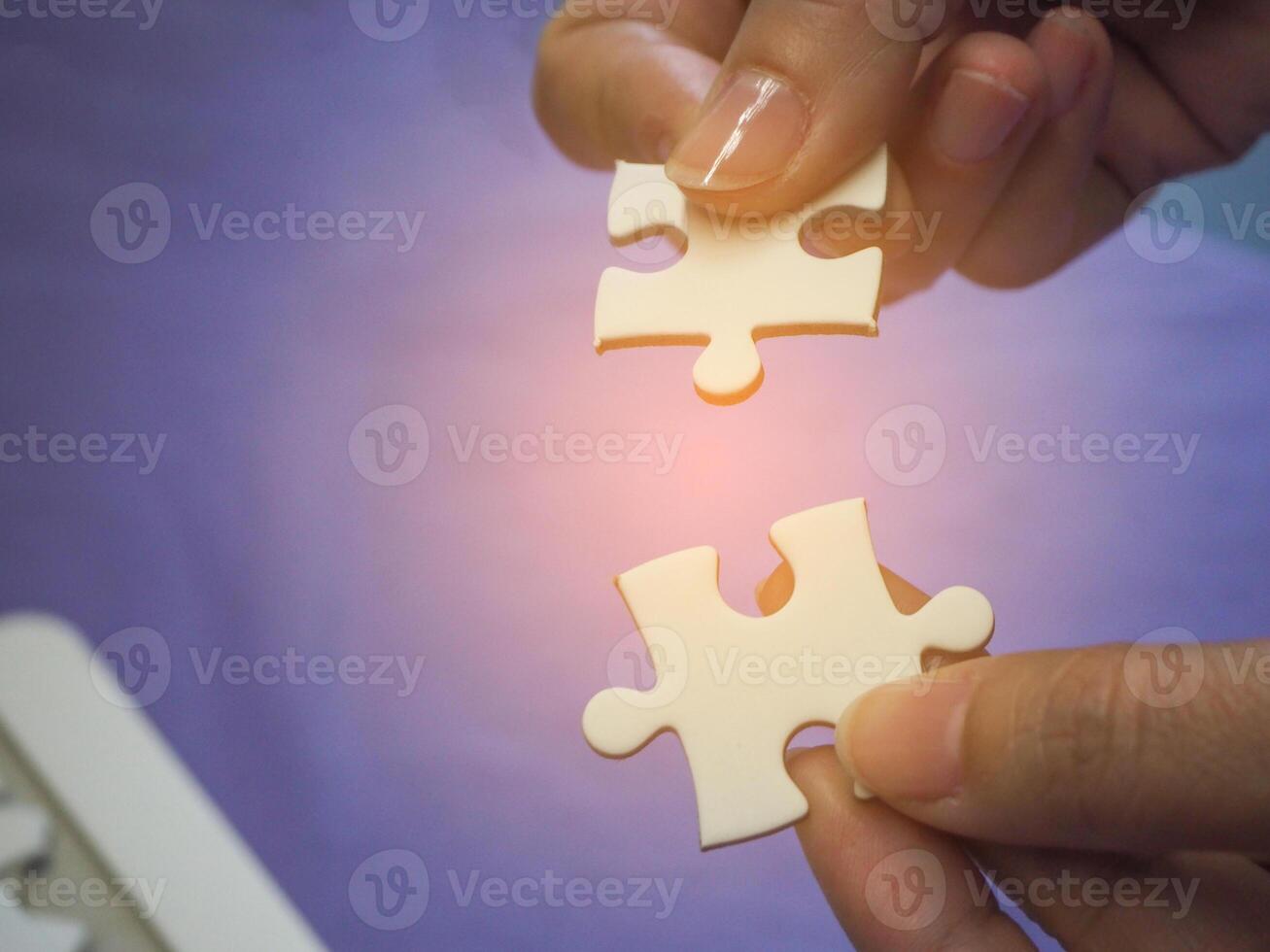 mãos do uma mulher segurando e conectando quebra-cabeças enigma com uma azul fundo e luz solar efeito. espaço para texto. conceito do o negócio e parceiro foto