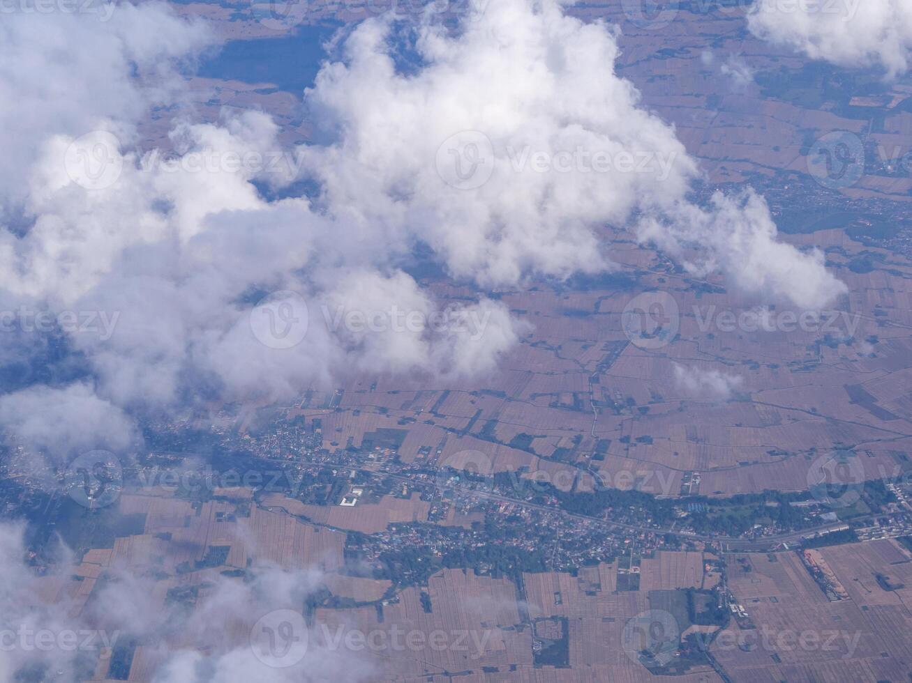 vista aérea de terras e nuvens vistas pela janela do avião foto