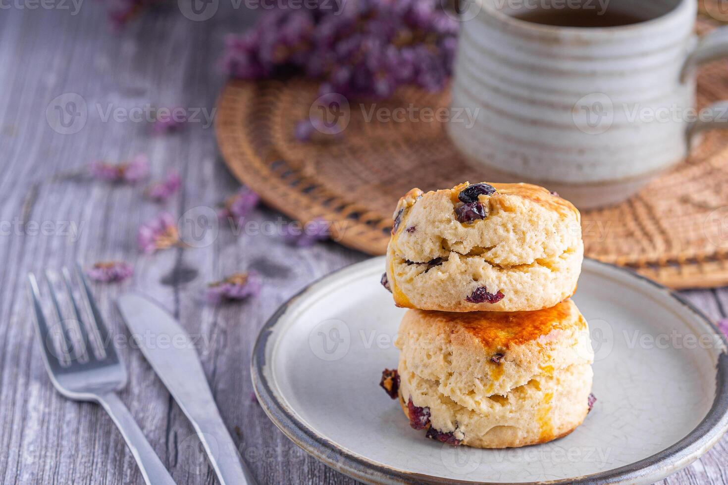 fechar-se do tradicional britânico scones em uma prato e uma chá quente copo com borrado fundo. espaço para texto foto