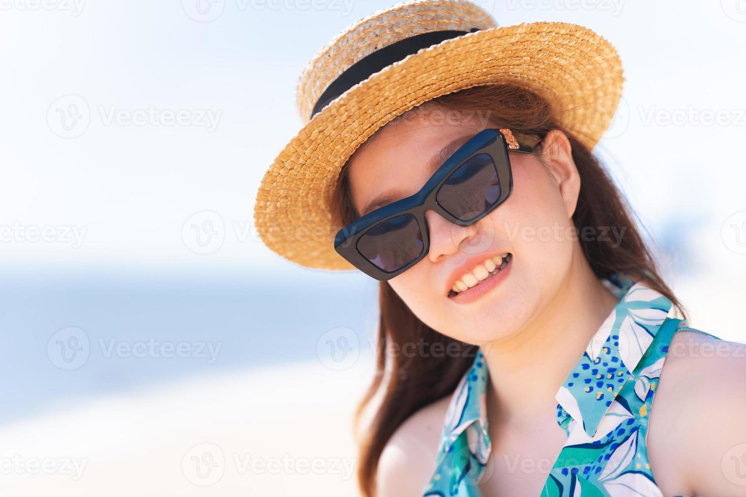 retrato de doce mulher asiática sorrindo na praia. lindas mulheres usando óculos escuros e chapéu de palha. pessoa feliz com o horário de verão. viajar Ásia em Pattaya Tailândia. foto