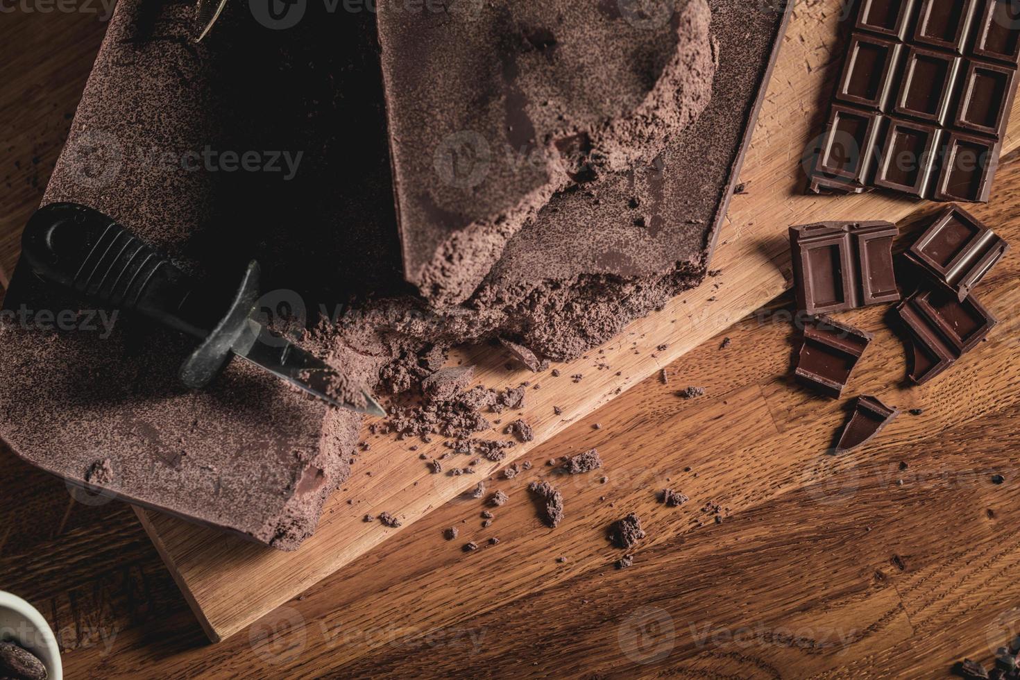 doce mesa vista de cima arranjo de grãos de cacau, nibs e barras de chocolate foto