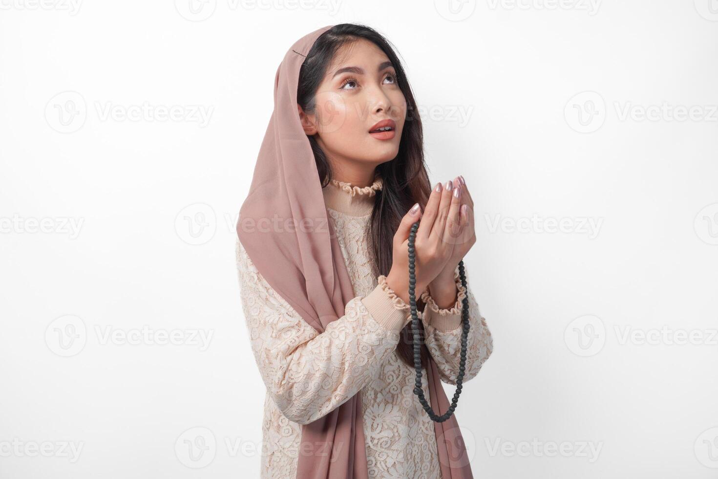 lindo ásia muçulmano mulher Rezar para Deus fervorosamente, Rezar gesto com mãos elevado acima e segurando oração pérola. Ramadã e eid Mubarak conceito foto