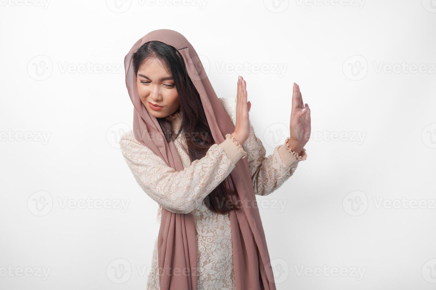 jovem ásia muçulmano mulher vestindo véu hijab gesticulando uma não rejeição, recusar usando mãos e dedos, isolado de branco fundo. Ramadã e eid Mubarak conceito foto