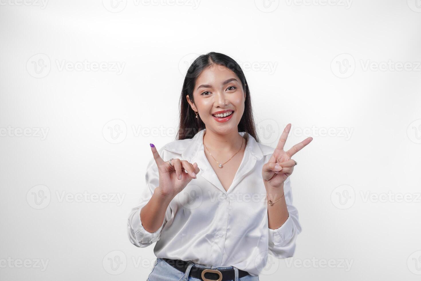 animado ásia jovem mulher mostrando pequeno dedo mergulhado dentro roxa tinta depois de votação para pemilu ou Indonésia eleição e apontando com dedos número 1 dois três, em pé em isolado branco fundo foto