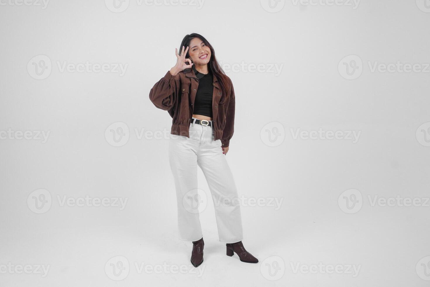 animado jovem ásia mulher fazer e mostrando OK placa com dedos vestindo casual roupas em isolado branco fundo foto