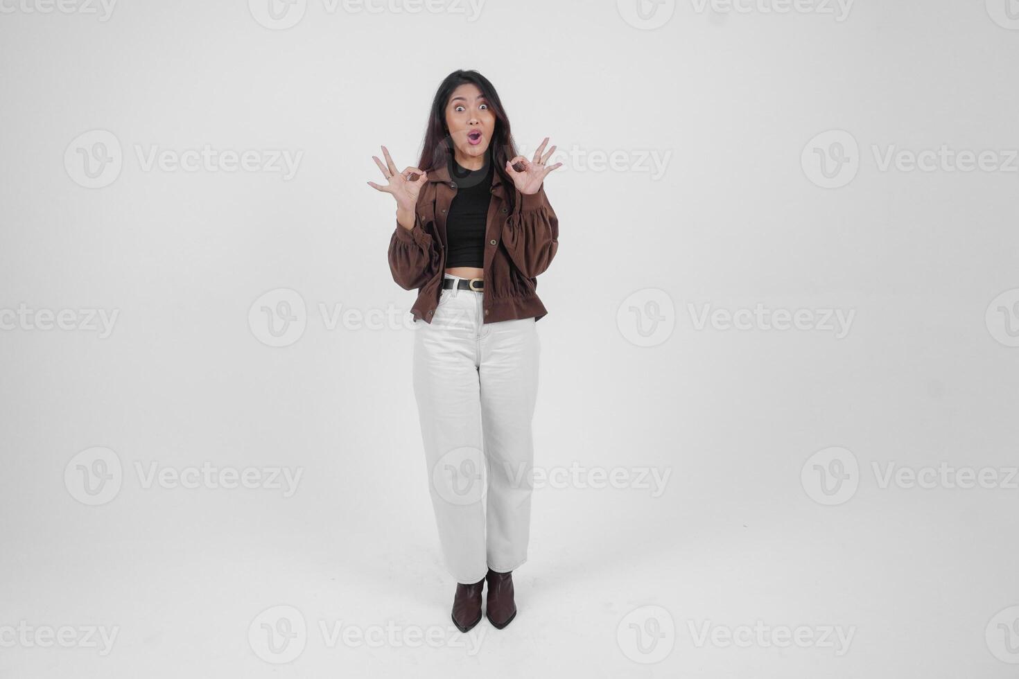 animado jovem ásia mulher fazer e mostrando OK placa com dedos vestindo casual roupas em isolado branco fundo foto