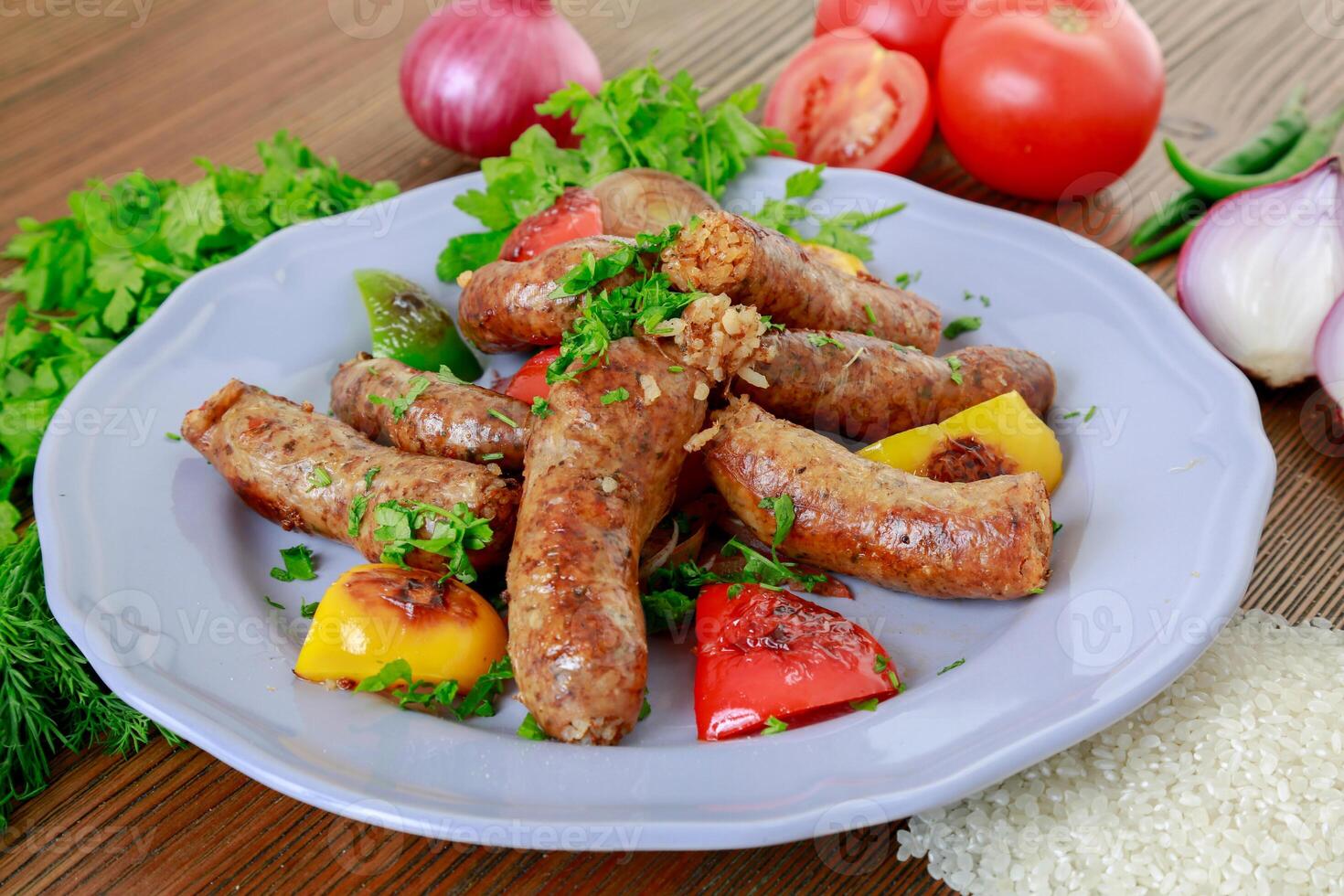 grelhado murmúrio ou linguiça grade amontoar-se com cebola, tomate e coentro servido dentro prato isolado em mesa lado Visão do árabe Comida foto