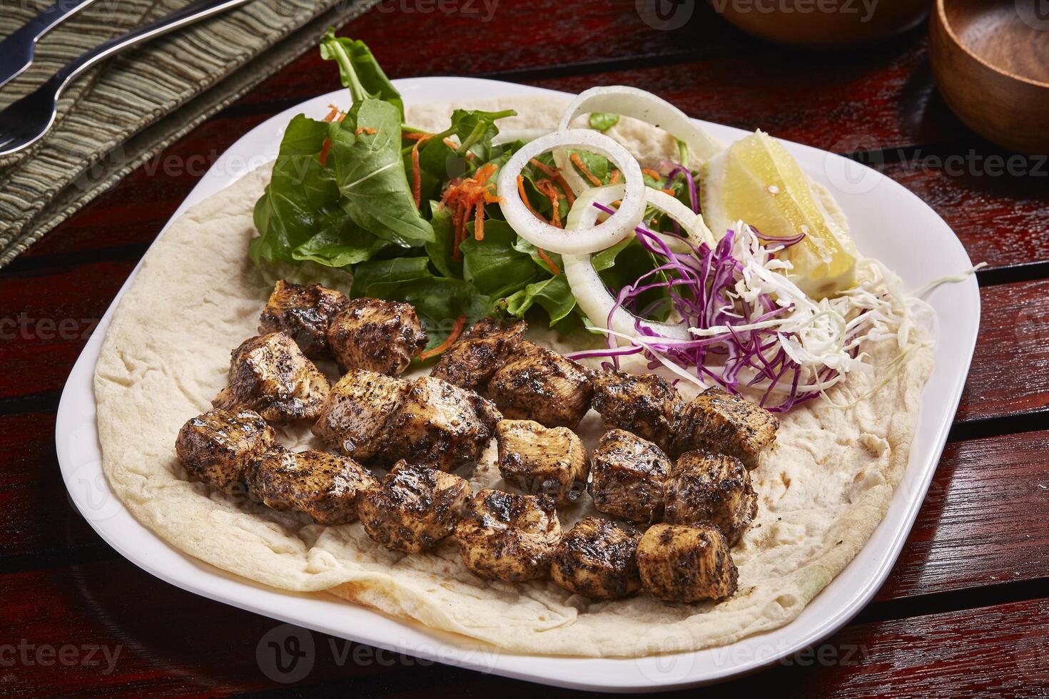 picante churrasco frango tikka boti kabab com pão, limão e salada servido dentro prato isolado em mesa lado Visão do meio leste Comida foto