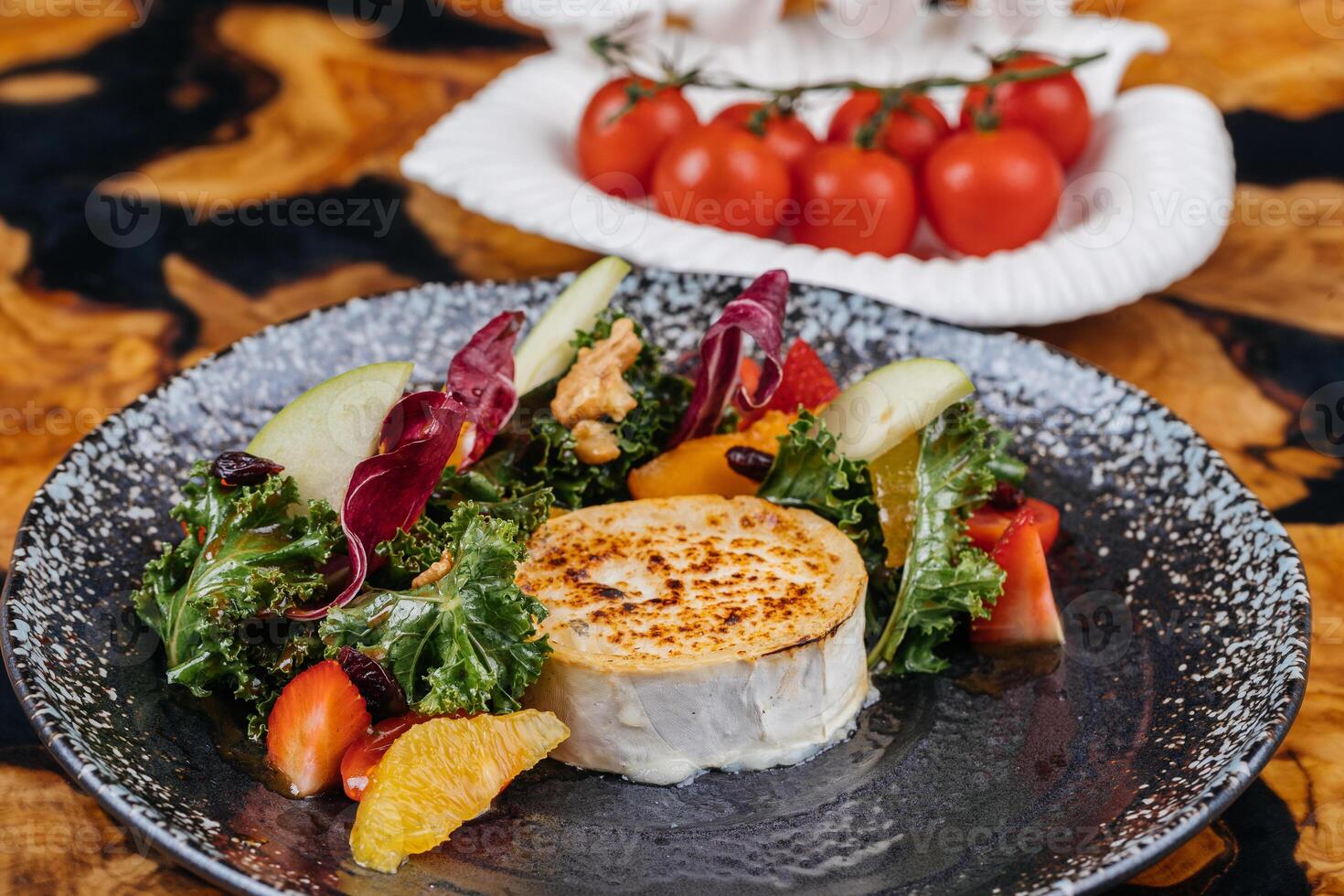 couve caramelizado bode queijo salada com morango, alegre tomate, noz, laranja e alface folha servido dentro prato isolado em mesa lado Visão do saudável orgânico salada foto