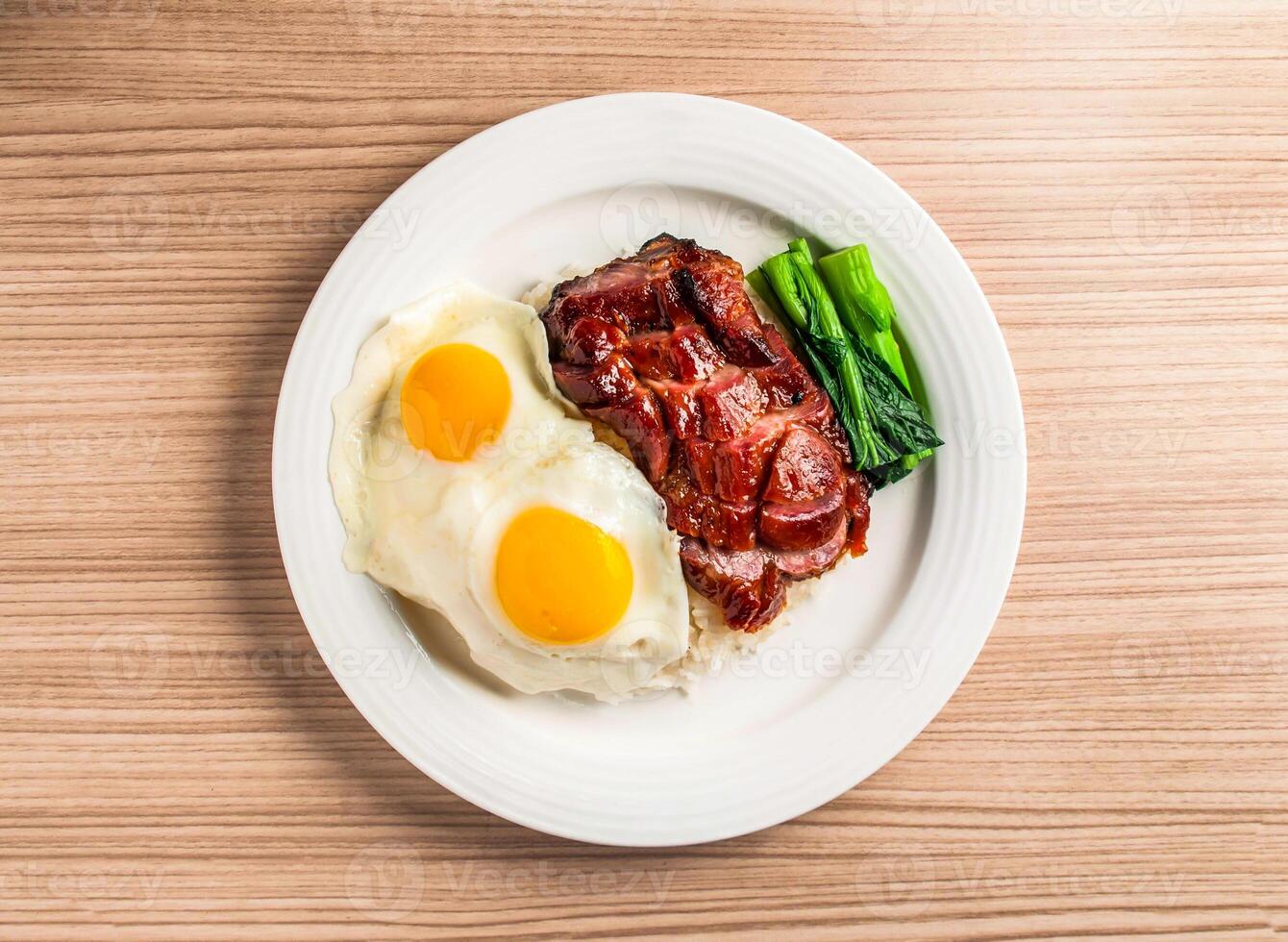 assado carne de porco com frito ensolarado ovo e arroz servido dentro prato isolado em mesa topo Visão do hong kong Comida foto