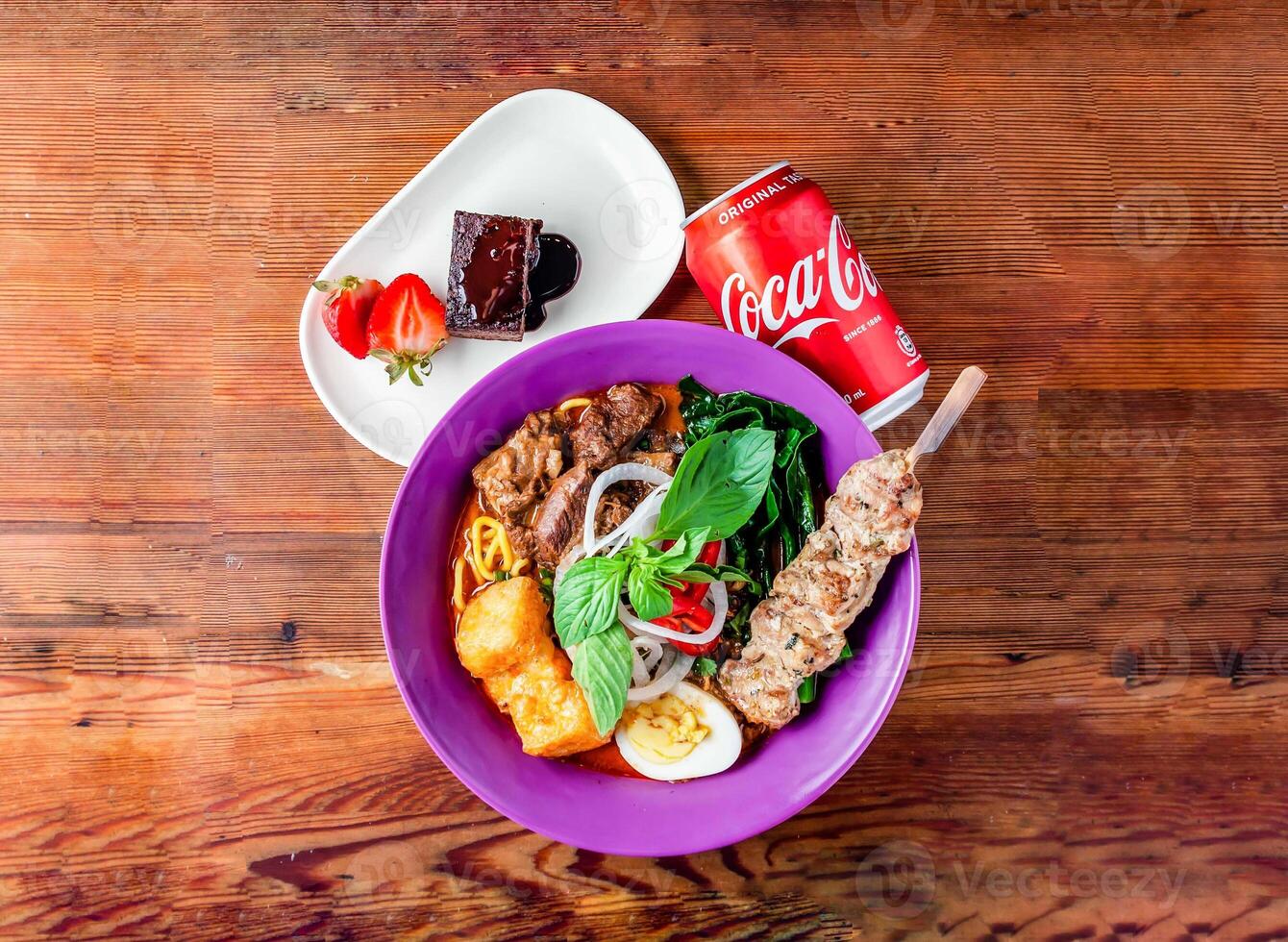 carne macarrão sopa com espeto, morango, Brownie e Coca pode 330 ml servido dentro prato isolado em de madeira mesa topo Visão do hong kong Comida foto