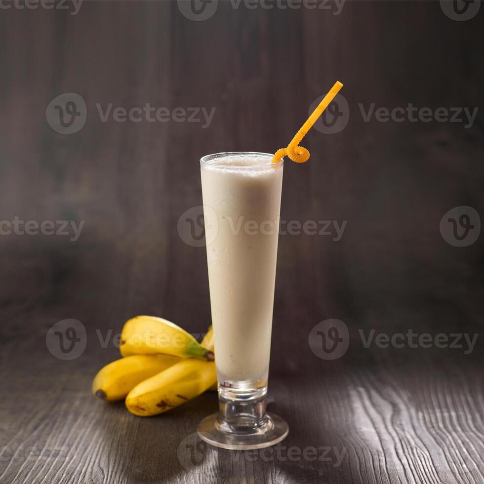 banana milkshake com Palha servido dentro vidro isolado em mesa lado Visão saudável manhã beber foto