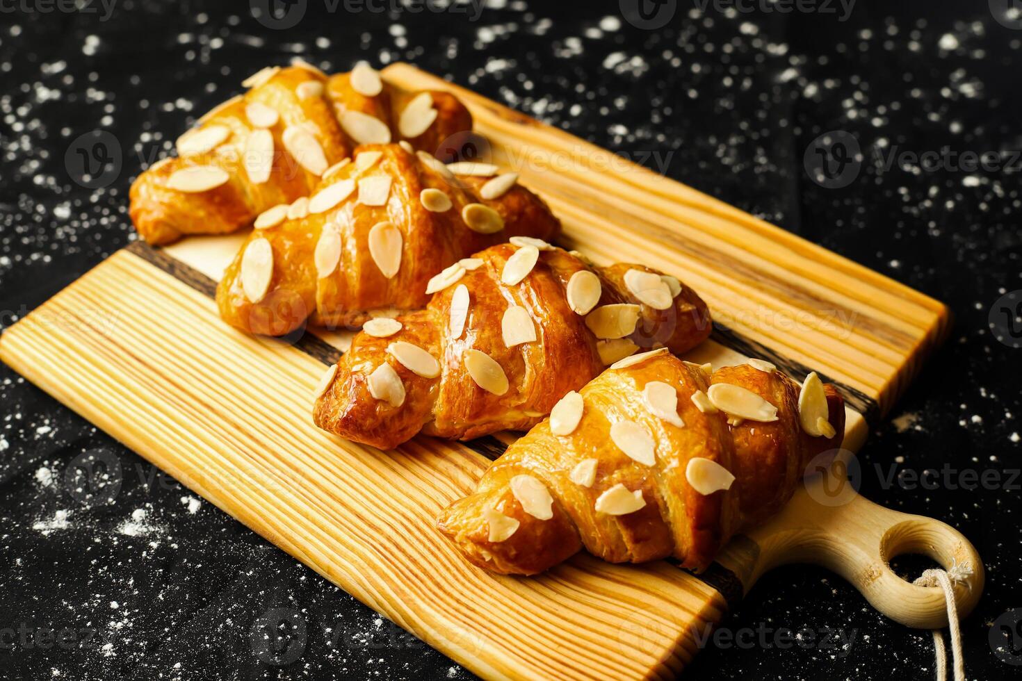 amêndoa croissant cobertura com nozes servido em de madeira borda lado Visão do francês café da manhã cozido Comida item foto