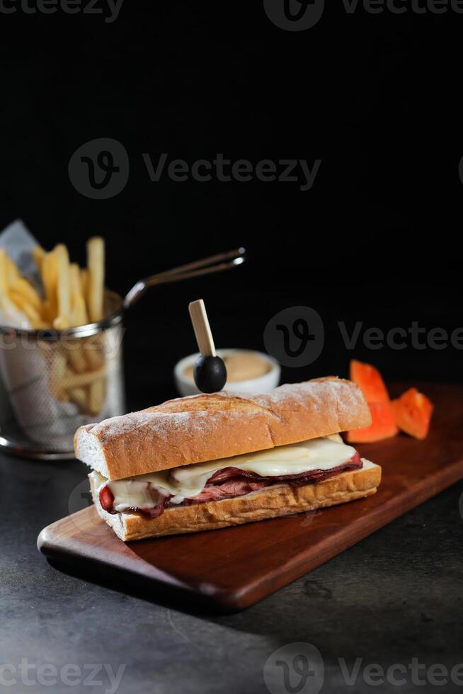 assado carne sub sanduíche com francês fritas balde servido em de madeira borda isolado em Sombrio fundo lado Visão do café da manhã Comida foto