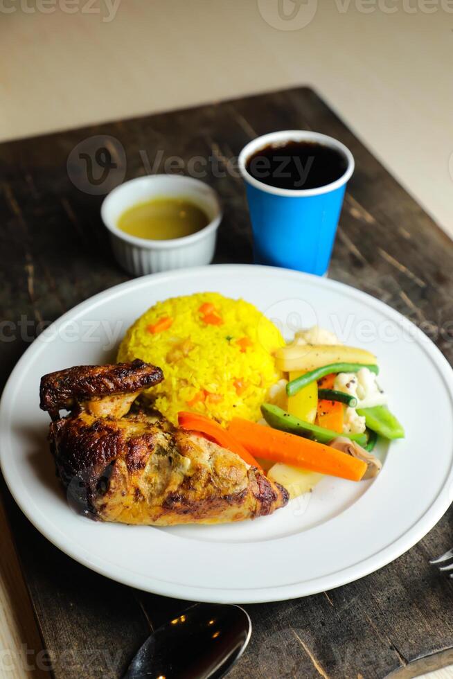 arroz com frango assado refeição com salada servido dentro prato com molho, frio bebida, colher e garfo isolado em de madeira borda lado Visão do tailandês Comida foto