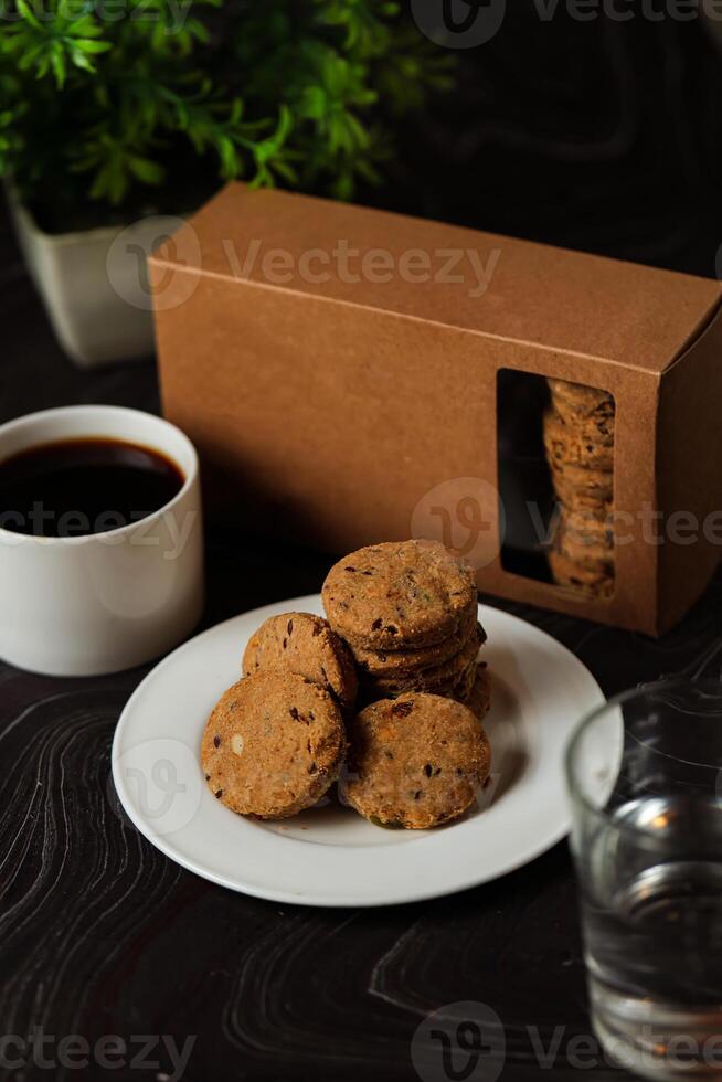 crocante biscoitos biscoitos servido dentro prato com bolacha caixa, Preto café e vidro do água isolado em mesa lado Visão do americano cafeteria cozido Comida foto