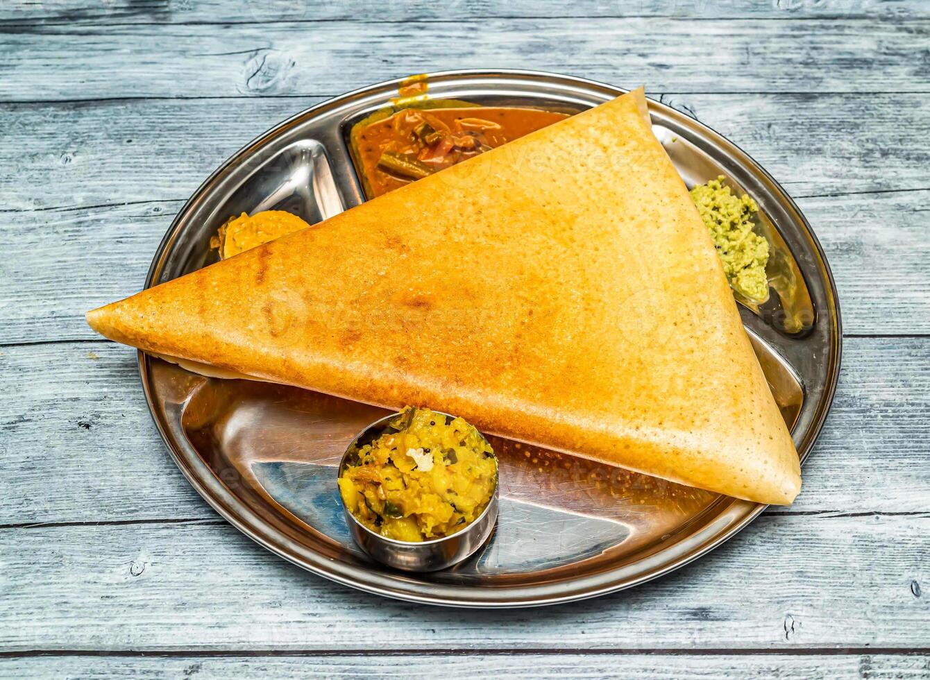 Masala dosa thali conjunto com sabji e molho picante servido dentro prato isolado em de madeira mesa topo Visão do indiano picante Comida foto