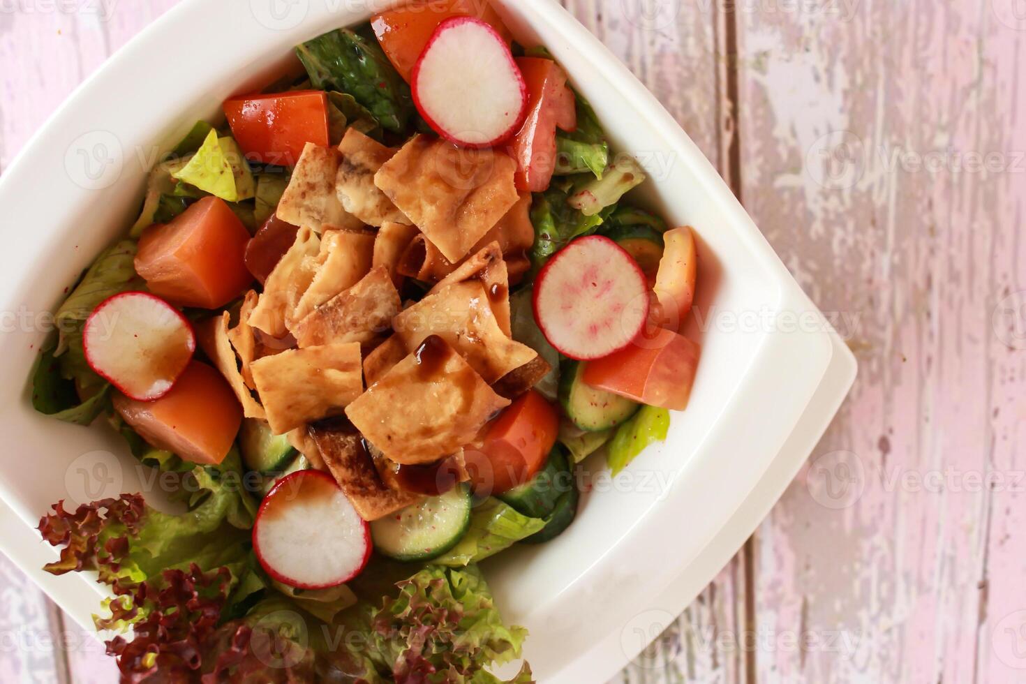 Fattoush salada com biscoitos, tomate, pepino, e alface folha servido dentro prato isolado em mesa fechar-se topo Visão do saudável orgânico Comida foto