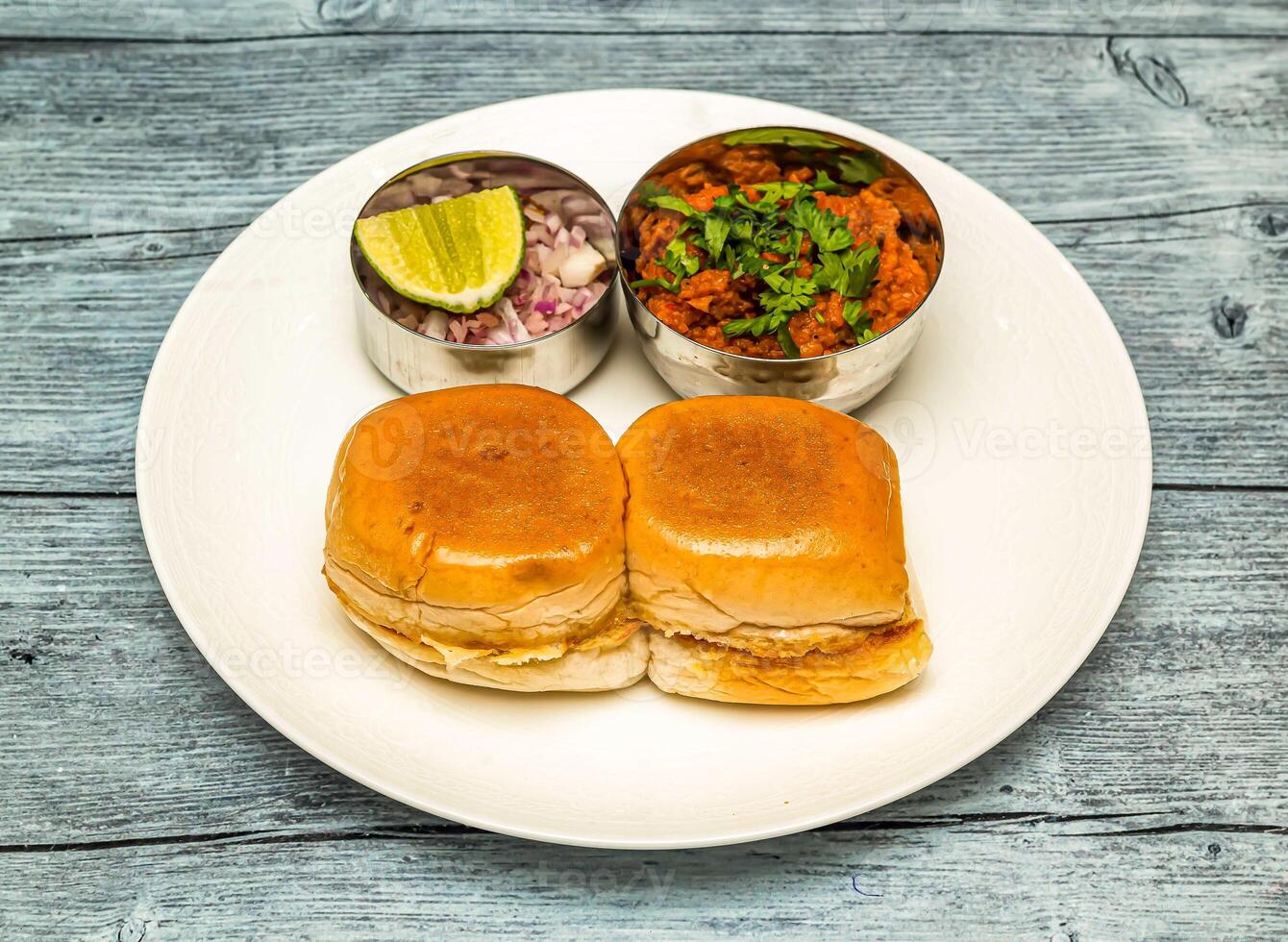 frango pav bhaji ou vada pav pão kabab com limão e cebola servido dentro prato isolado em de madeira mesa topo Visão do indiano picante Comida foto