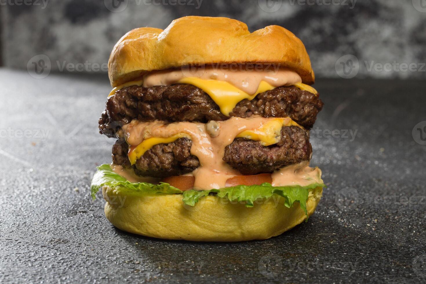 picante Duplo carne hamburguer incluir tomate, alface folha, derretido queijo e maionese isolado em Sombrio cinzento fundo lado Visão do velozes Comida sanduíche foto