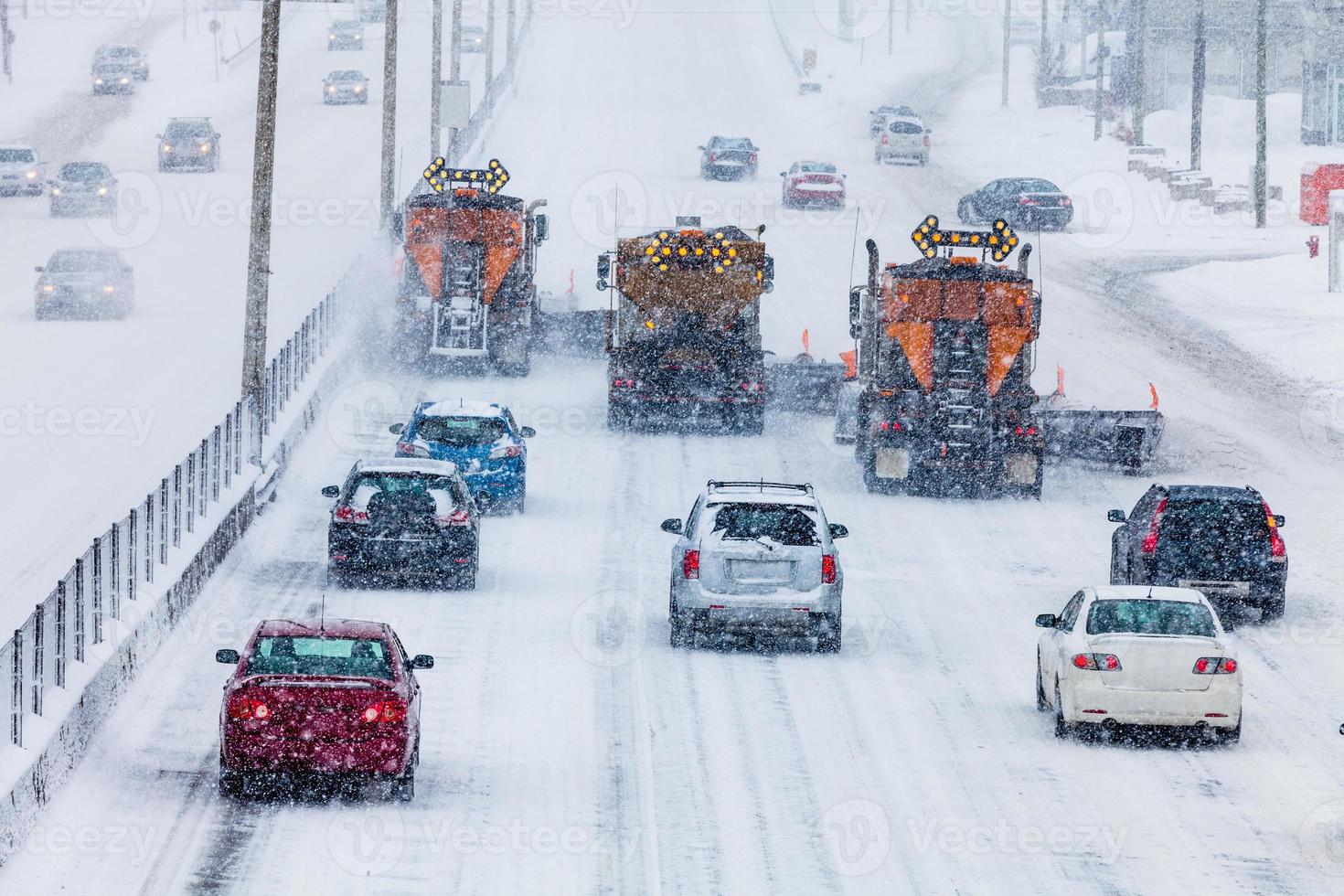 limpadores de neve alinhados com árvores limpando a rodovia foto