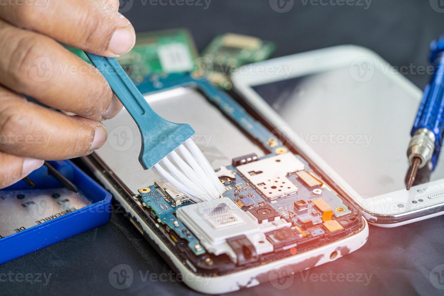 ásia técnico reparar e limpeza sujo micro o circuito a Principal borda do Smartphone eletrônico tecnologia com escovar, hardware, Móvel telefone, melhoria conceito. foto