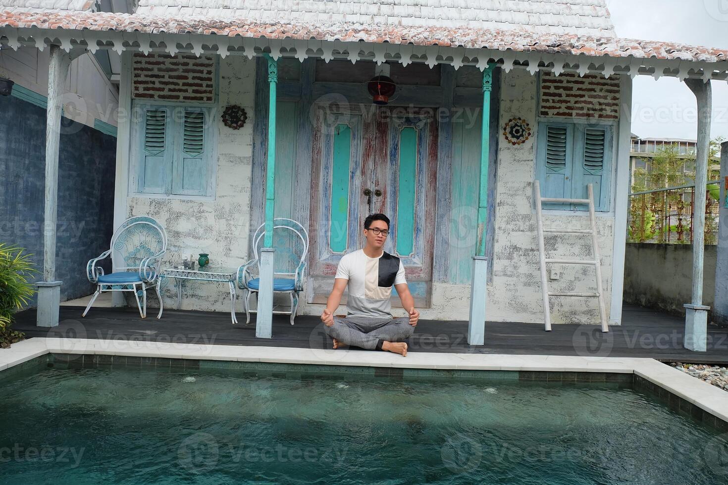 à beira da piscina serenidade, ásia modelo dentro lótus ioga pose, bali villa relaxamento foto