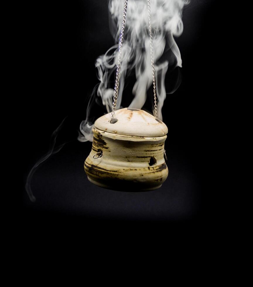tigela do incenso suspensão fumaça em Preto fundo foto